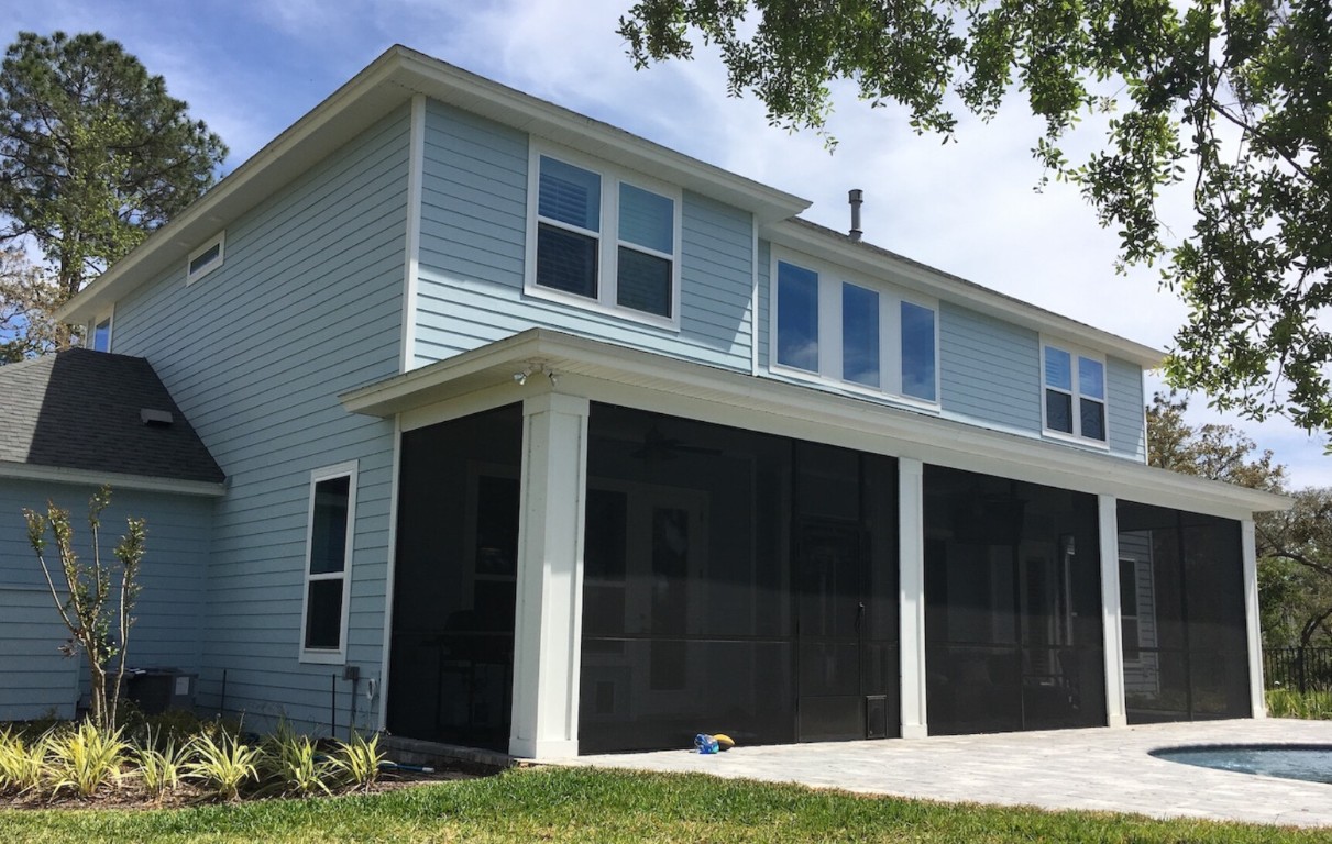 Sunroom conversion with black screening on blue house
